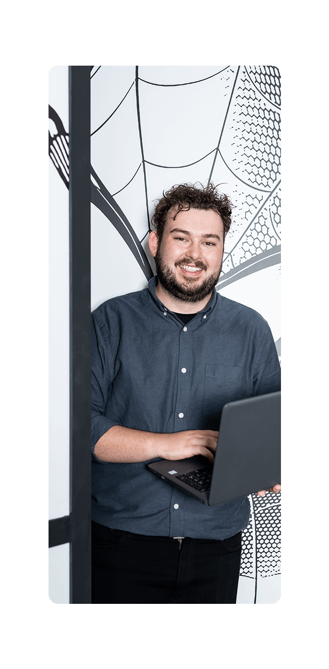 office worker holding laptop leaving a room