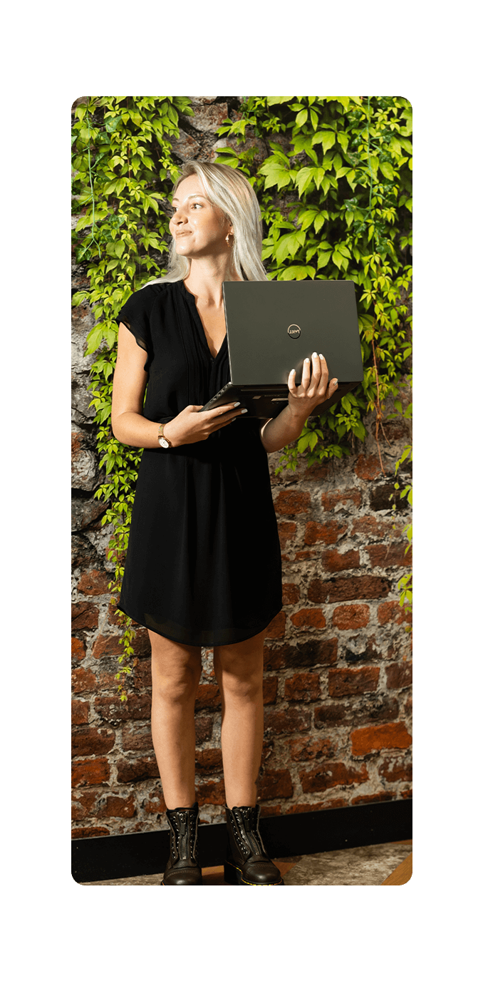 female office worker in front of leaf covered brick wall